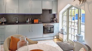 Una cucina moderna con mobili grigi, forno integrato e un'ampia finestra.