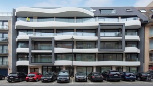 A multi-story building with a modern design, featuring balconies and large windows. - Newly-built Apartment by the sea (Middelkerke)