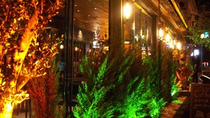 Un restaurante con iluminación interior y vistas a la calle.
