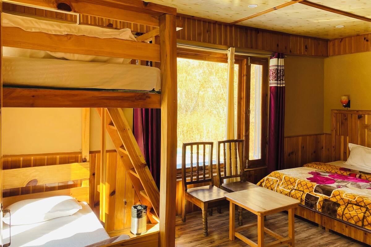 A cabin-style room with bunk beds, a small table, and a chair.