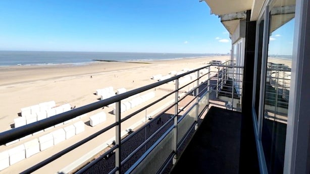 Ein Balkon mit Blick auf Strand und Meer.
