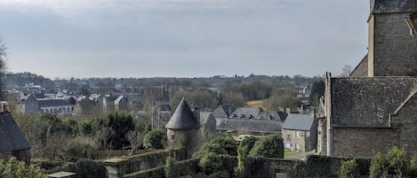Un bâtiment historique doté d’une tour imposante et d’un pont de pierre menant à une cour intérieure.