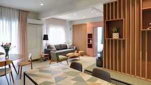 A modern living room with a sofa, coffee table, and dining area.