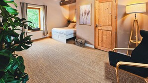 A bedroom with a bed, a chair, a lamp, and a large plant. - 1BDR Apt + Sofa Bed w/ Garden + Jacuzzi (Étivey)