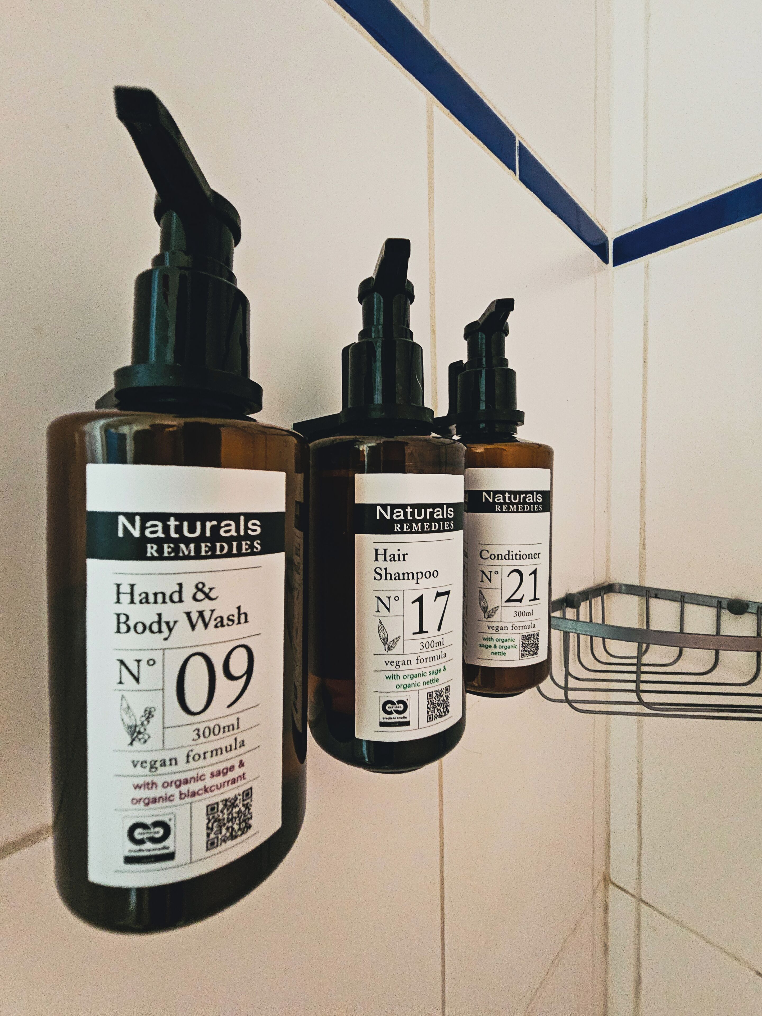 Three bottles of Naturals Remedies products on a tiled wall.