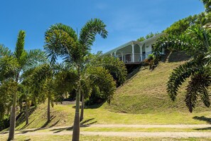A house with a balcony overlooking a grassy hill. - Villa Big Blue  (Le François)