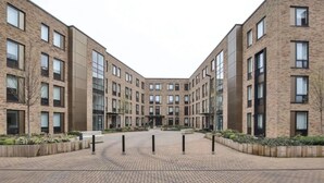 Un bâtiment moderne à l’architecture symétrique, doté de plusieurs étages et d’une cour intérieure.
