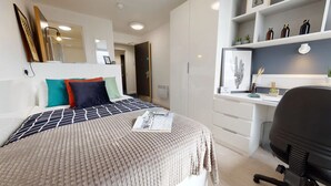Une chambre à coucher moderne avec un lit, un bureau et une chaise.