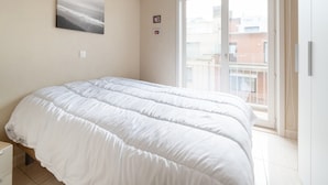 Une chambre à coucher avec un lit, une fenêtre et une porte.
