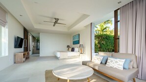 A spacious living room with a sofa, a round coffee table, and a television.