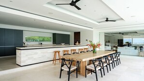 Una cocina moderna con una isla central, taburetes de bar y una mesa de comedor con sillas.