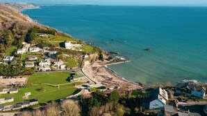 Un village côtier avec des maisons, une plage et une vue dégagée sur la mer.
