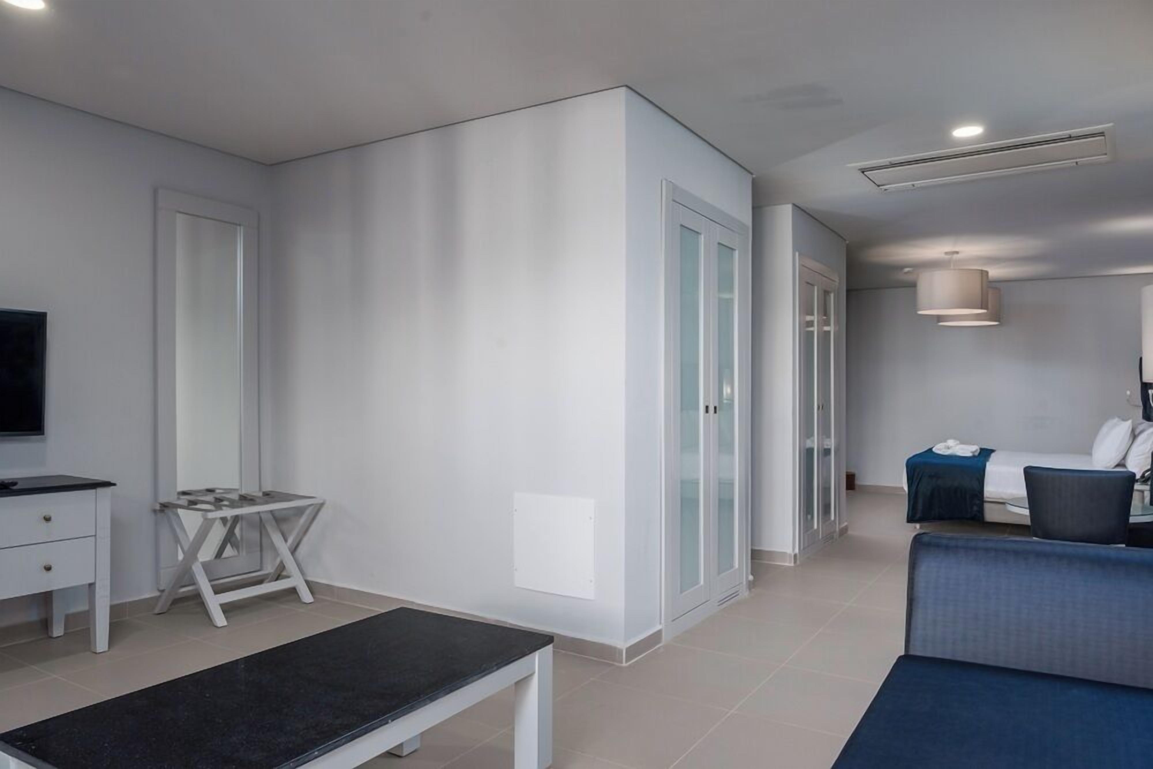 Una habitación de hotel moderna con una cama, un escritorio, una silla y un televisor.