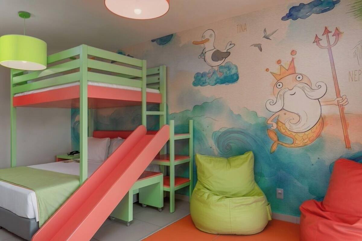 Een kinderkamer met stapelbedden, een glijbaan en een muurschildering.