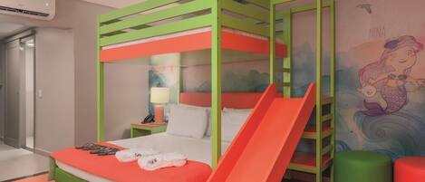 A colorful children's room with a bunk bed, a slide, and a mural of a mermaid.