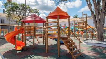 A playground with a slide, climbing structures, and a covered area.