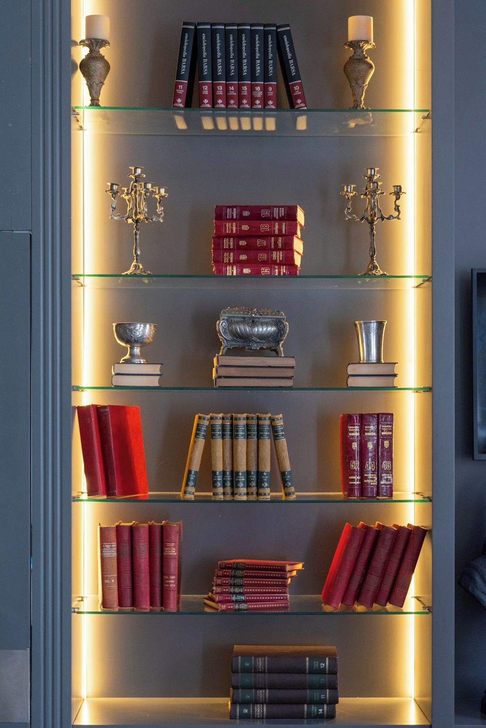 A bookshelf with multiple shelves, each containing books and decorative items.