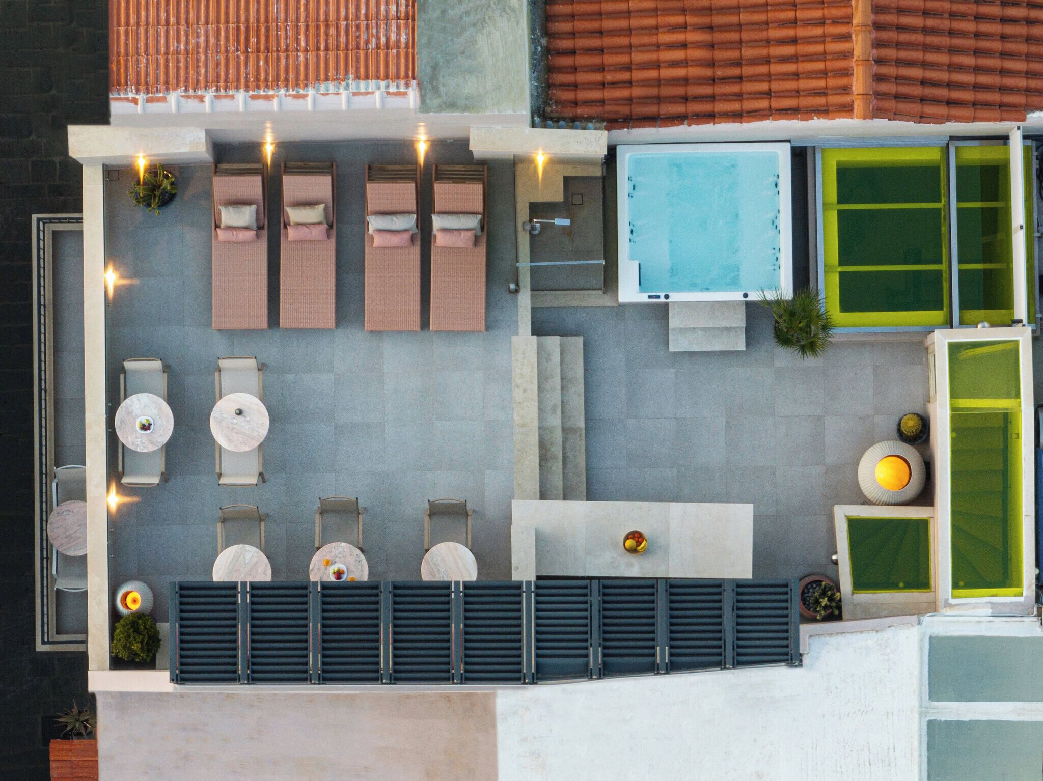 A rooftop terrace with seating, a pool, and a green wall.
