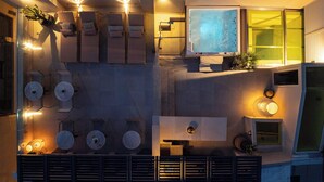 Une terrasse sur le toit dotée de plusieurs chaises longues, d’un téléviseur à écran plat et d’un éclairage d’ambiance.