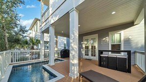 Un espace extérieur abrité comprenant une piscine, des sièges et un barbecue.