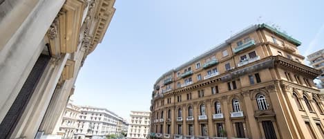 A multi-story building with classical architecture, featuring balconies and large windows.