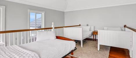 A bedroom with a bed, a desk, and a chair.