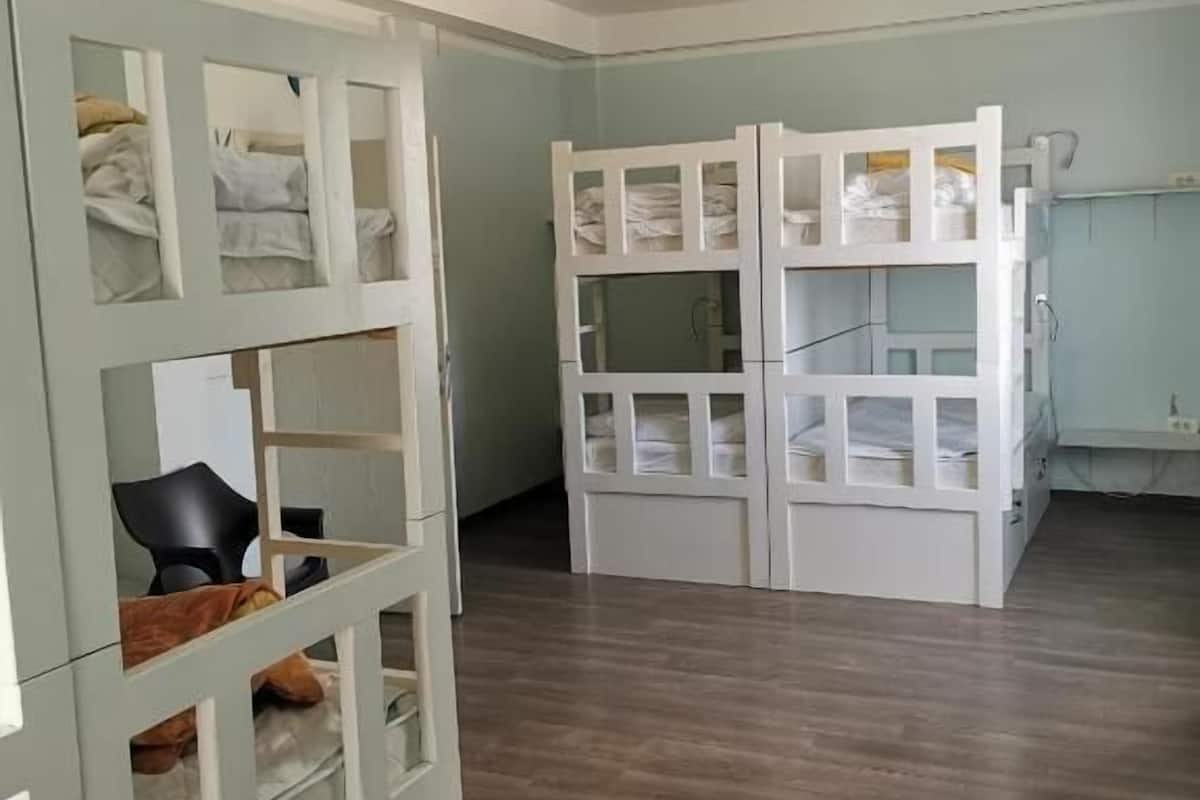 Ein Zimmer mit einem Etagenbett, einem Schreibtisch und einem Stuhl.