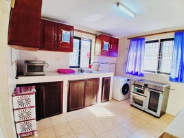 Una cocina compacta equipada con microondas, lavadora y estufa.