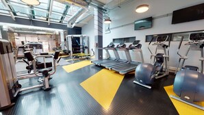 Ein modernes Fitnessstudio mit Laufbändern, Crosstrainern und Gewichte.