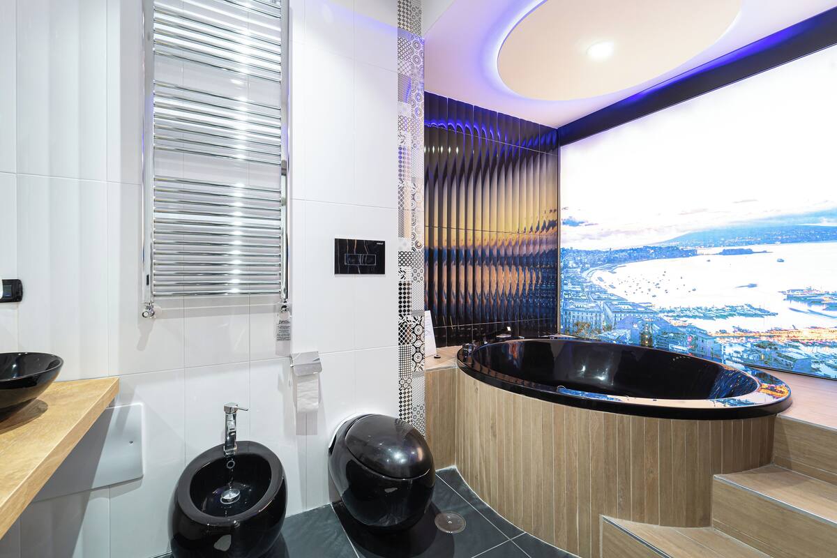 A modern bathroom with a large bathtub, a toilet, and a sink.