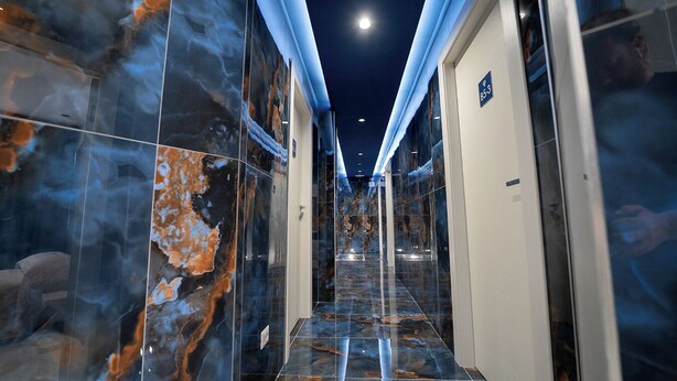 A hallway with marble walls and a glass door, leading to a room with a sign indicating room number 853. - P.C. BOUTIQUE H. LIFESTYLE NAPOLI CENTRO by ClaPa Group Dislocated Hospitality (Naples)