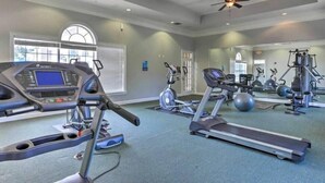 Ein Fitnessstudio mit Laufbändern, Crosstrainern und Kurzhanteln.