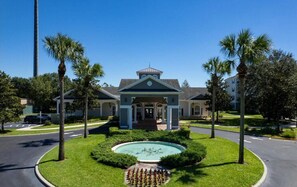Un hotel con un cortile centrale, palme e una fontana.