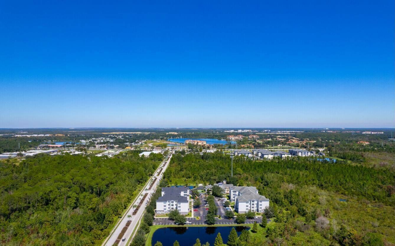 Vista aérea de una zona residencial con varios edificios, carreteras y una gran masa de agua.