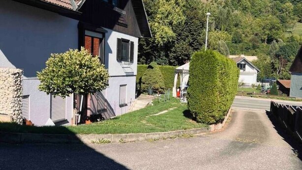 A residential street with houses, a well-maintained lawn, and a clear sky. - Vacation apartment - Klenk - 1 (Gruibingen)