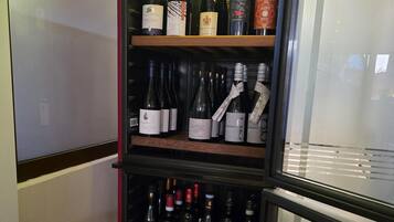 A wine display case with various bottles of wine, including brands like Skandiluxe, Ferran, and Barolo.