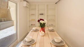 Ein Esstisch, gedeckt mit Schüsseln, Tellern und einer Blumenvase.