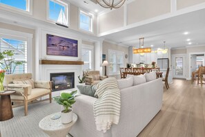 TV, fireplace, books - Down By The Sea: Modern Coastal Home with Hot Tub (Oak Island)