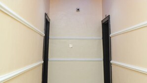 Un couloir doté d’un plafond au design moderne, comprenant des luminaires encastrés et une caméra de surveillance.