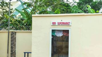 Een laag, klein gebouw met een bord dat boven een raam "MINI SUPERMARKET" vermeldt.