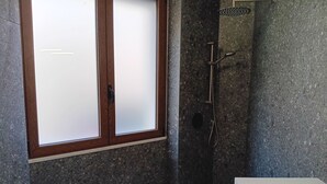 A bathroom with a large window, a shower, and a bathtub. - Double Room. The Garden. Rooms & Breakfast. (La Maddalena)