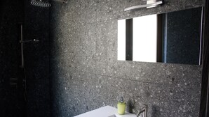A modern bathroom with a white sink, a mirror, and a shower area. - Double Room. The Garden. Rooms & Breakfast. (La Maddalena)