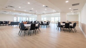 A spacious indoor area with multiple tables and chairs, large windows, and a clean, modern design. - The J Hotel Dunedin near Honeymoon Island State Park, an Ascend Collection Hotel (Dunedin)