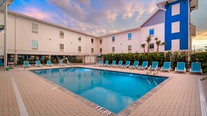 A swimming pool with lounge chairs, a 5 ft depth sign, and a building with a blue and white facade. - The J Hotel Dunedin near Honeymoon Island State Park, an Ascend Collection Hotel (Dunedin)