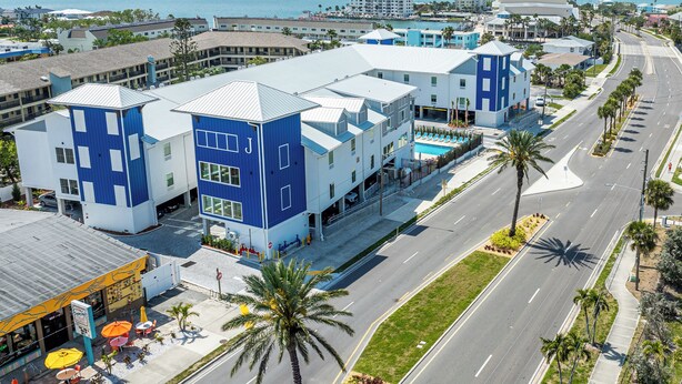 A modern hotel with a pool, located near a coastal road with palm trees. - The J Hotel Dunedin near Honeymoon Island State Park, an Ascend Collection Hotel (Dunedin)