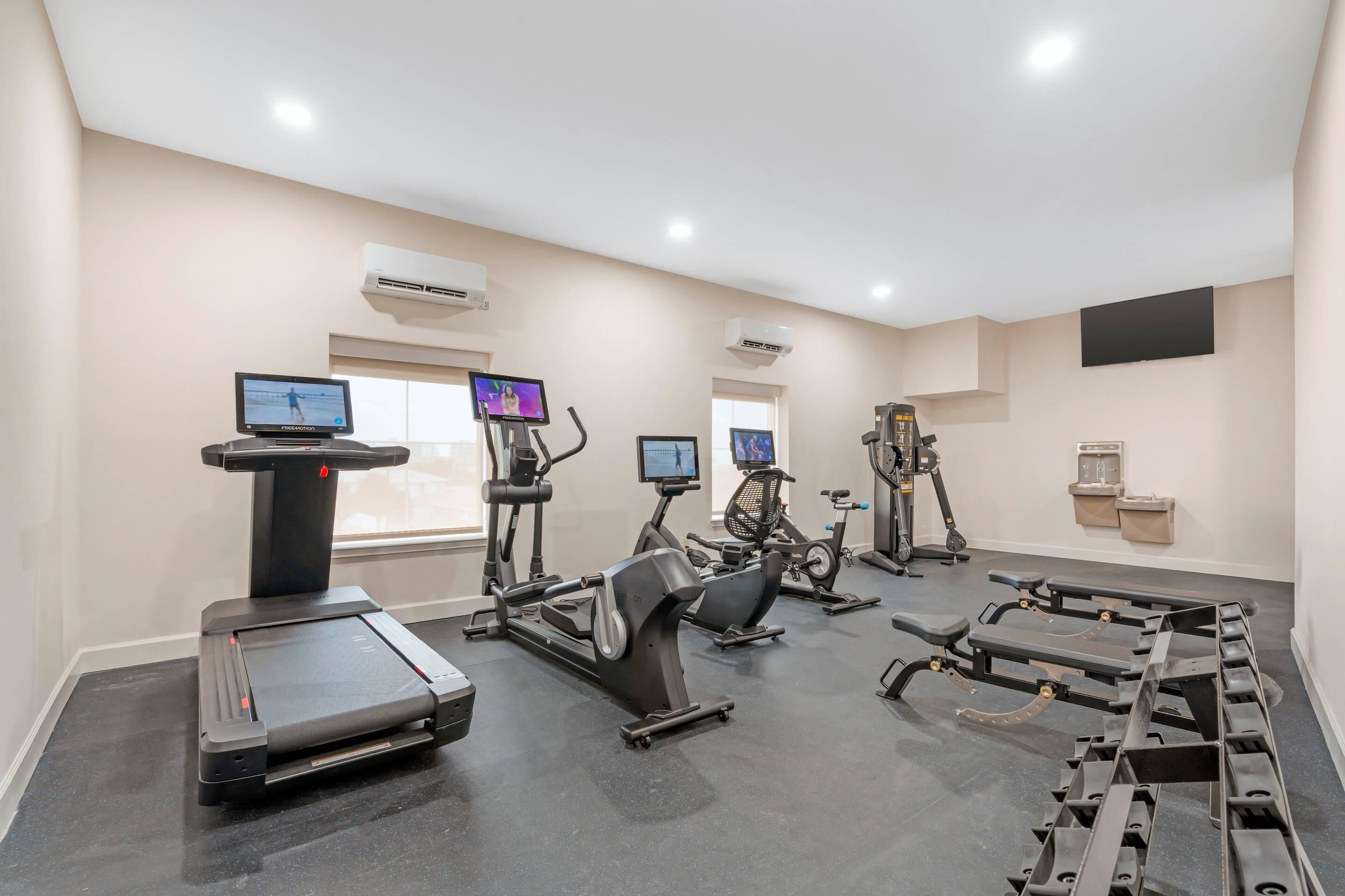 A gym with treadmills, stationary bikes, and weight machines.