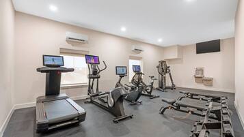 A gym with treadmills, stationary bikes, and weight machines.