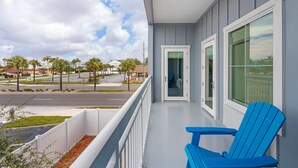 A balcony with a view of a street, a door, and a blue chair. - The J Hotel Dunedin near Honeymoon Island State Park, an Ascend Collection Hotel (Dunedin)