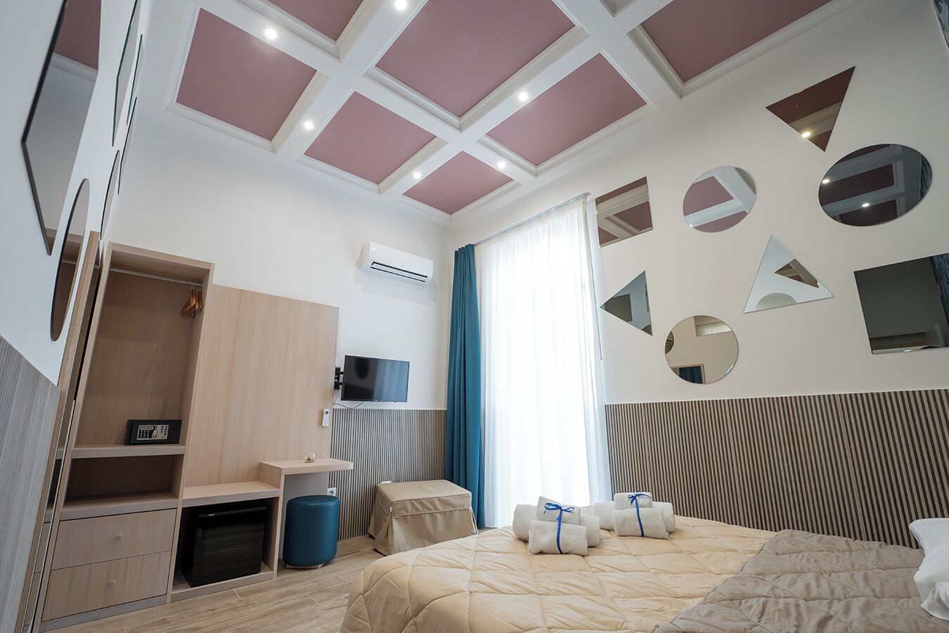 Una habitación de hotel moderna con cama, escritorio, armario y televisor.