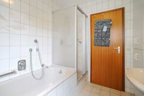 A bathroom with a bathtub, shower, and toilet. - Vacation apartment Klenk - 3 (Ostfildern)